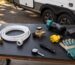 Generic RV hookup essentials arranged beside a travel trailer